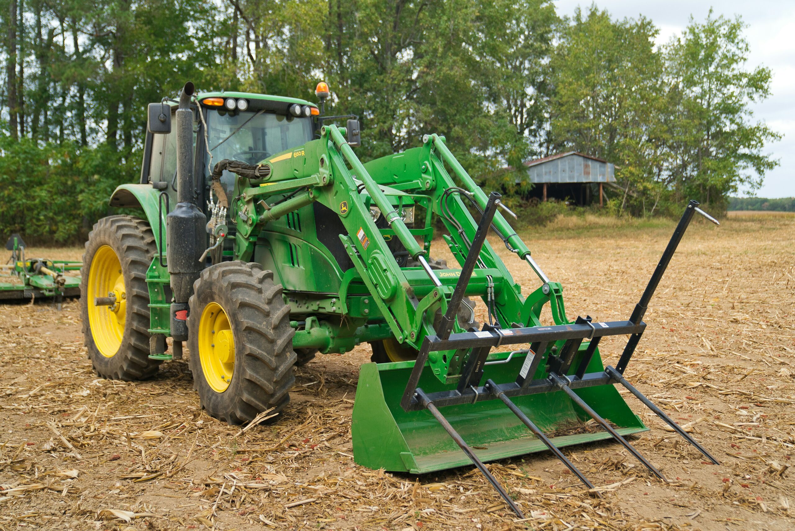 compact tractor with front end loader moving gravel