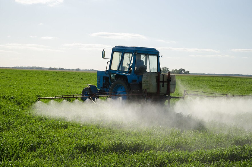 tractor spraying pesticides in field